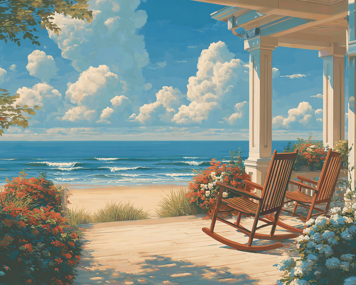 Rocking chairs on a porch overlooking the ocean with a clear blue sky.