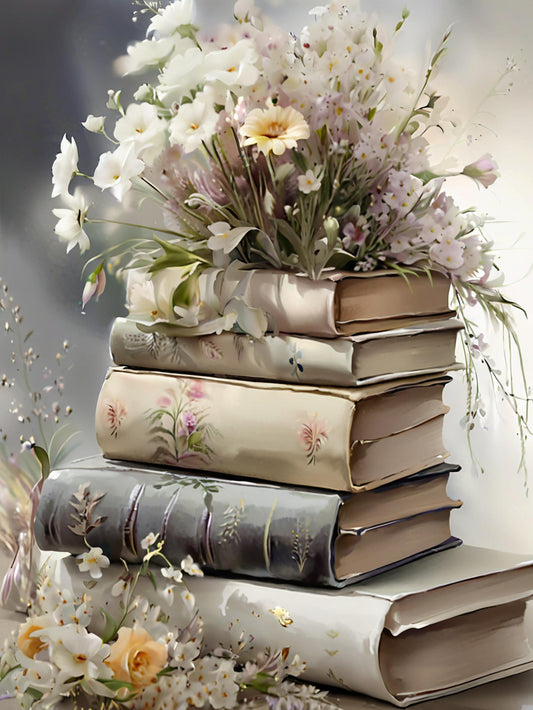 Stack of ornate books with floral arrangements on a soft background